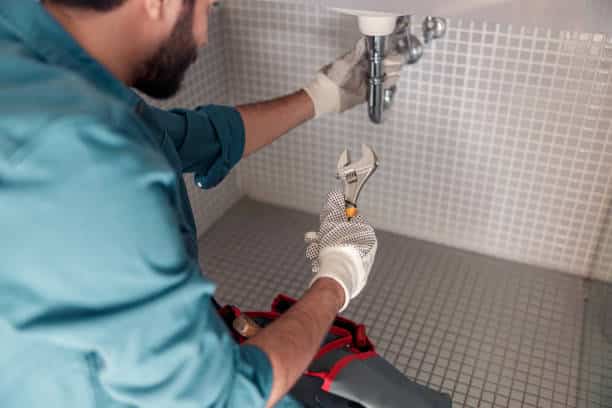 Plumbing Professional repairing faucet of sink at bathroom Plumbing Professional repairing faucet of sink at bathroom
