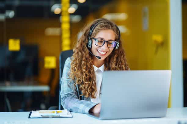 Virtual Receptionist with headset working on support hotline in office Virtual Receptionist with headset working on support hotline phone call in office