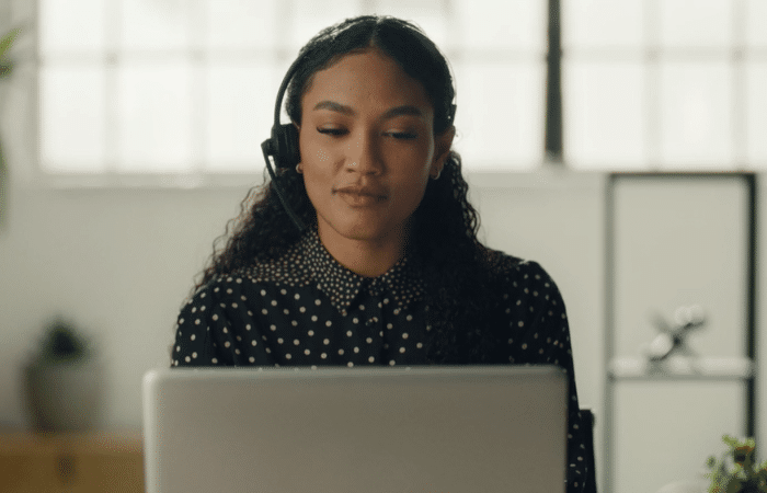 Posh Virtual receptionist behind desk answering calls Posh Virtual receptionist behind desk answering calls