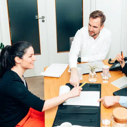 confident employees sitting in office and smiling due to virtual receptionist for business