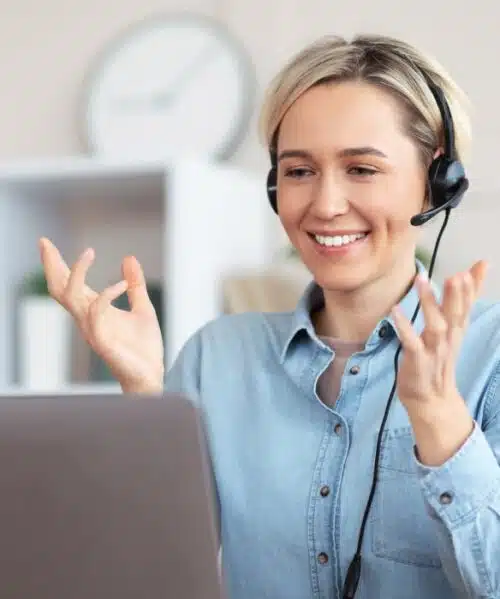 Bilingual virtual receptionist wearing a headset during a video call, assisting clients remotely.
