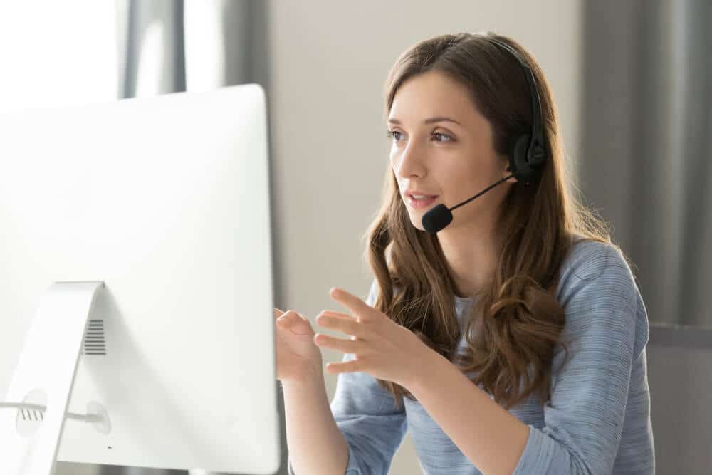bilingual-answering-service-for-law-firm Woman with headset providing bilingual virtual answering service for a law firm during a call at her desk