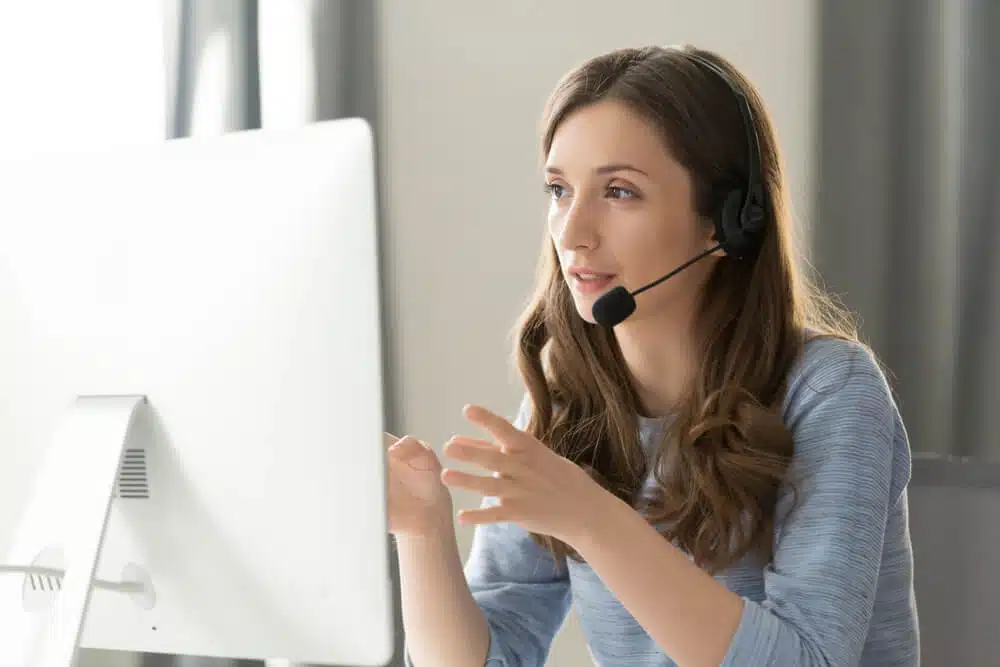 Woman with headset providing bilingual virtual answering service for a law firm during a call at her desk