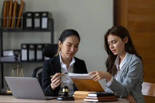 Law firm delegation strategy: Two professionals discussing legal documents in an office setting.