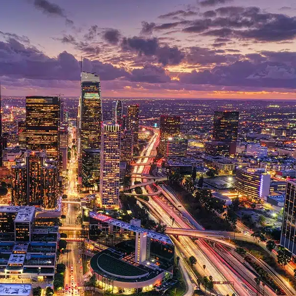 Los Angeles city lights at night with highways and tall buildings.