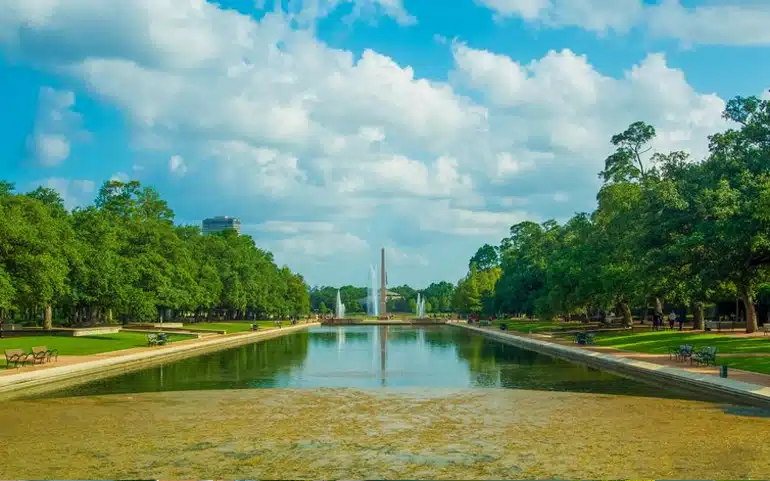 Beautiful water feature and tree-lined pathway at Hermann Park in Houston.