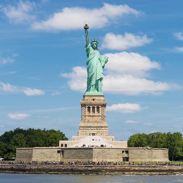 Statue of Liberty in New York City against a bright blue sky.