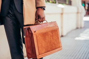 Attorney in business suit carrying a leather briefcase, representing Posh AI for law firms
